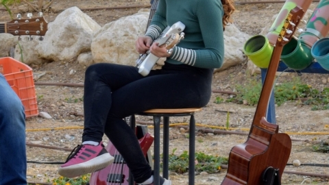 ילדה על במה מנגנת גיטרה חשמלית