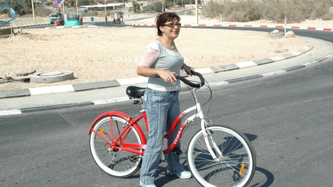 נאות הכיכר אישה על אופניים אדומים