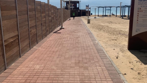 נקיון החוף מדרכות ליד גדר של החוף המופרד